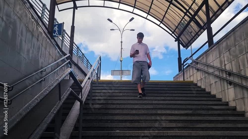 A teenage boy descends the steps of an underground passage