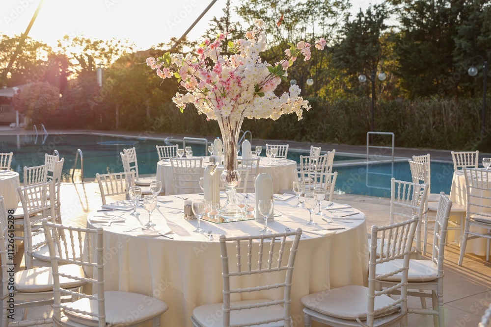 Beautiful Wedding Decor: Long Tables with Lush Floral Arrangements and White Chairs Outdoors