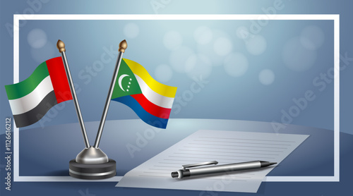United Arab Emirate and Comoros National flags on small table with bokeh background, cooperative relationship