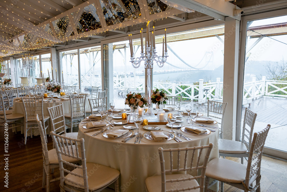 Elegant Indoor Table Setting with White Tablecloths and Floral Centerpieces