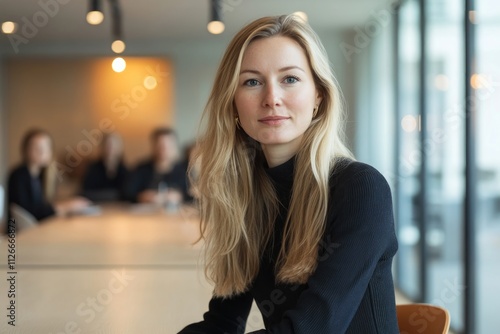 A female entrepreneur is seated at a conference table, engaged in a professional meeting with a group a people 