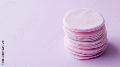 A stack of pink pads sits on a purple background