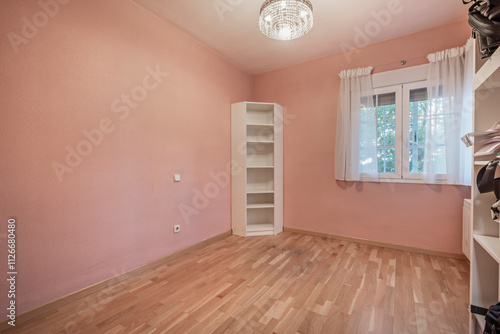 A practically empty room with some white furniture and pink painted walls photo