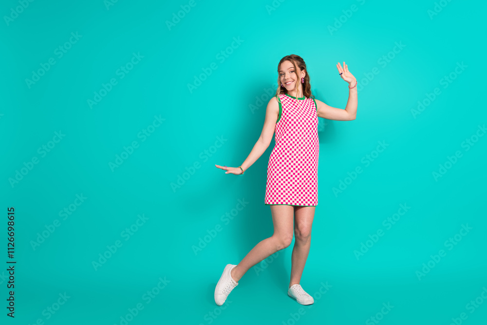 Full size photo of pretty teen girl dance have fun wear trendy plaid pink outfit isolated on cyan color background Full size photo of pretty teen girl dance have fun wear trendy plaid pink outfit isolated on cyan color background