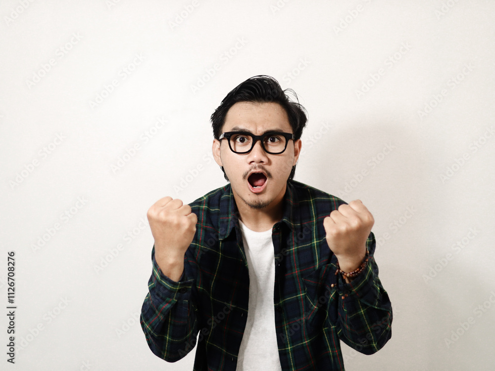 Adult Asian clenched fist showing success gesture isolated on white background Adult Asian clenched fist showing success gesture isolated on white background