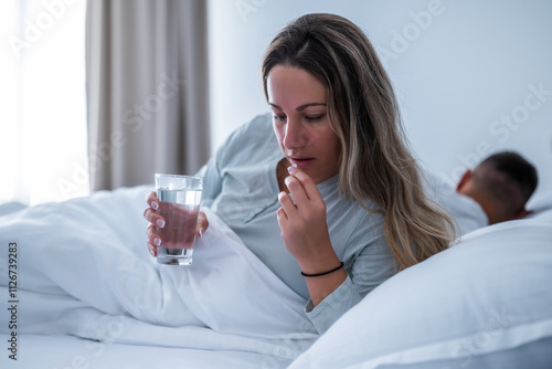 Slika na platnu Woman can not sleep. She is taking sleeping pill.