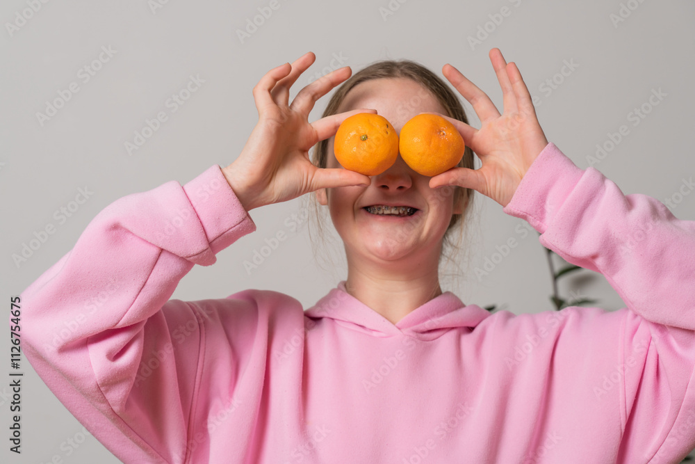 Woman with braces holds tangerines and has fun Woman with braces holds tangerines and has fun
