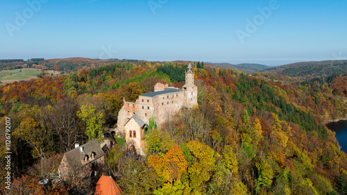 Zamek Grodno w Zagórzu Śląskim jesienią, otoczony kolorowymi drzewami i malowniczymi widokami.