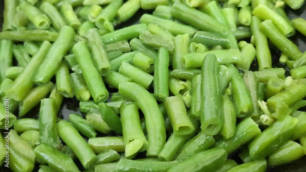 Frozen green beans cooking process. Fresh vegetables fried in olive oil on the pan. Frozen green beans cooking process. Fresh vegetables fried in olive oil on the pan.