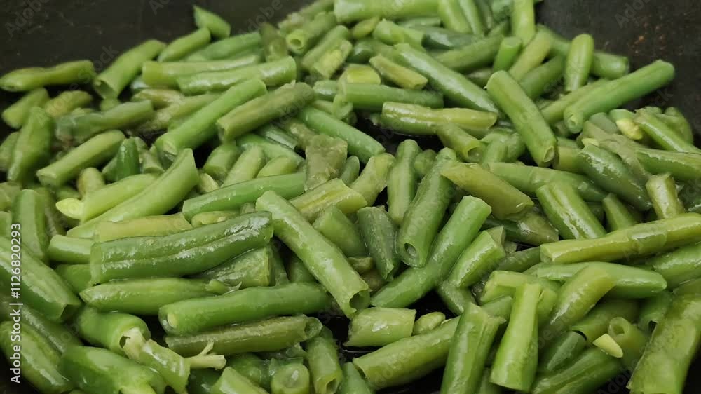 Frozen green beans cooking process. Fresh vegetables fried in olive oil on the pan. Frozen green beans cooking process. Fresh vegetables fried in olive oil on the pan.