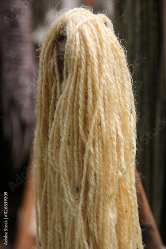 Natural undyed wool threads hanging for crafting