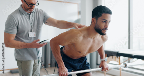 фотографія Physiotherapy, consulting and monitor with man in clinic for biofeedback, muscle stimulation and track progress