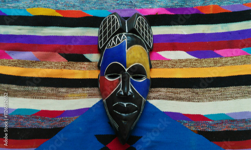Принти на полотні Gabonese wooden mask matches the colors and patterns of a Tunisian Amazigh Margoum carpet