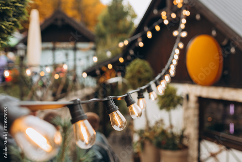 Obraz na płótnie Hanging Outdoor String lights. Decorative Outdoor Street electric garland. Old light bulbs. Lamp hang in the yard. Terrace concept. Festoon string lights decoration at the party w salonie
