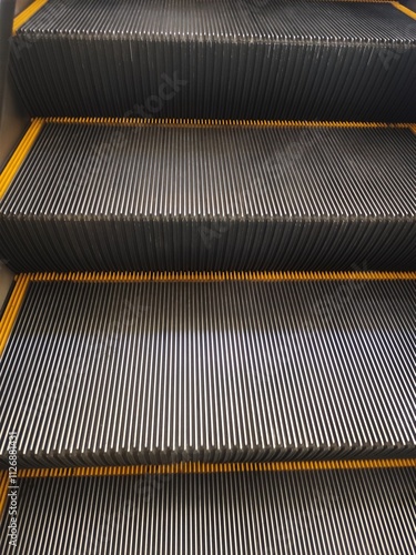 A close-up view of the escalator, highlighting the metallic steps and yellow side panels