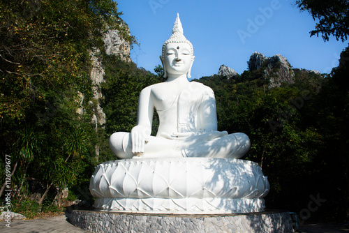 White holy buddha ancient statue on mountain in forest for thai people travelers travel visit respect blessing wish mystery at Wat Khao Wong Narai Cave Temple in Phra Phutthabat of Saraburi, Thailand photo