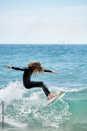 Surfboarder with long hair riding a wave