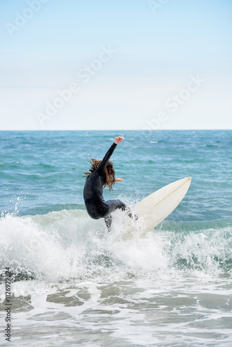 Surfboarder with long hair riding a wave