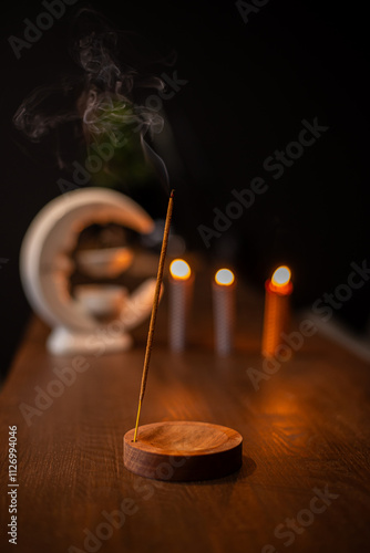 incense stick smokes on a wooden stand on a dark background. Aromatherapy, Smoke while burning incense. smoke for prayers and meditation. prayer to buddha. incense for relaxation and yoga