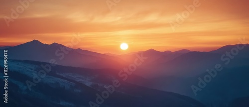 A panoramic shot of a snowy landscape with a sun setting in the background
