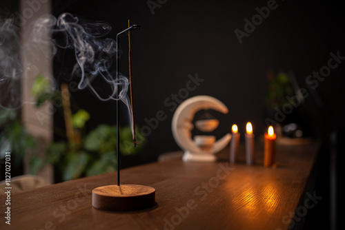 incense stick smokes on a wooden stand on a dark background. Aromatherapy, Smoke while burning incense. smoke for prayers and meditation. prayer to buddha. incense for relaxation and yoga