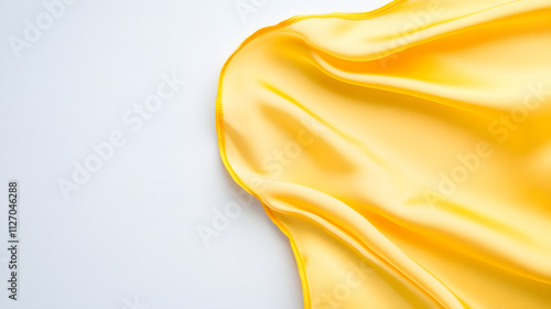 Piece of yellow golden folded silk sheet on a white background, top view with copy space photo