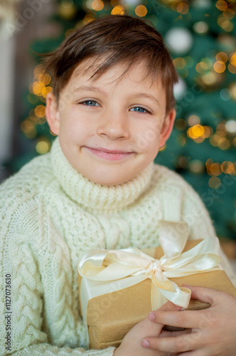 boy in a white sweater with a gift