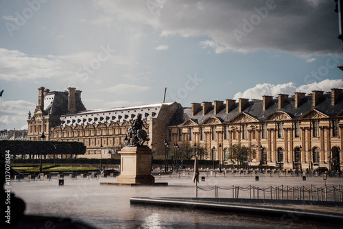 Louvre pyramid under the sun with the ground wet after a day of rain