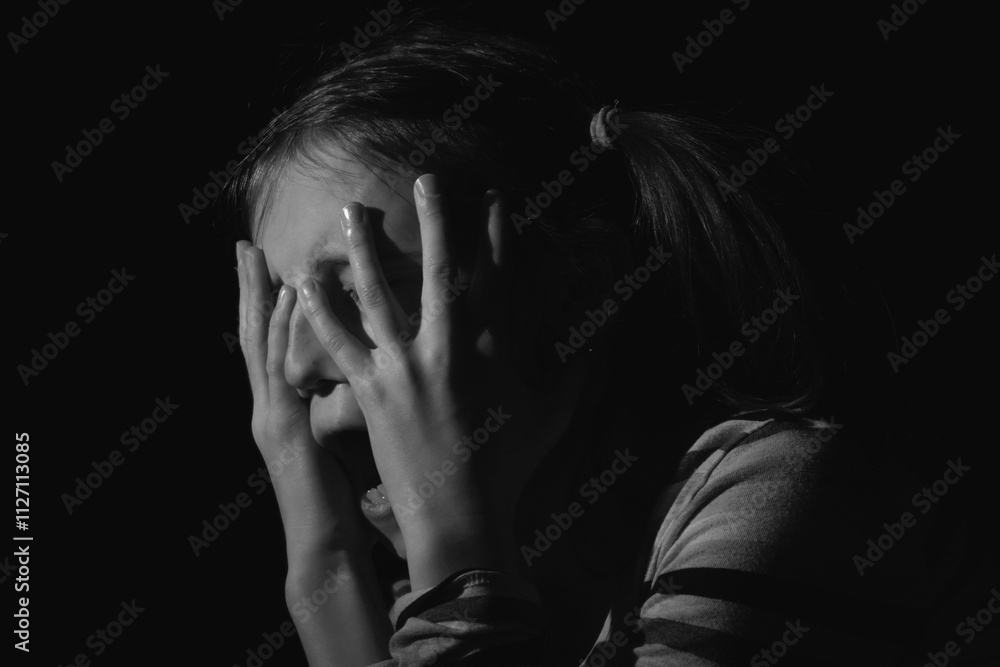 Stressed, unhappy young adolescent girl crying and feeling exhausted or depressed alone. Horizontal black and white image. Stressed, unhappy young adolescent girl crying and feeling exhausted or depressed alone. Horizontal black and white image.