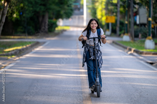 A woman is riding a scooter down a street