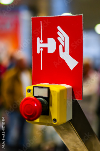 Red Reset button on the wall. red emergency stop switch button in a factory building.