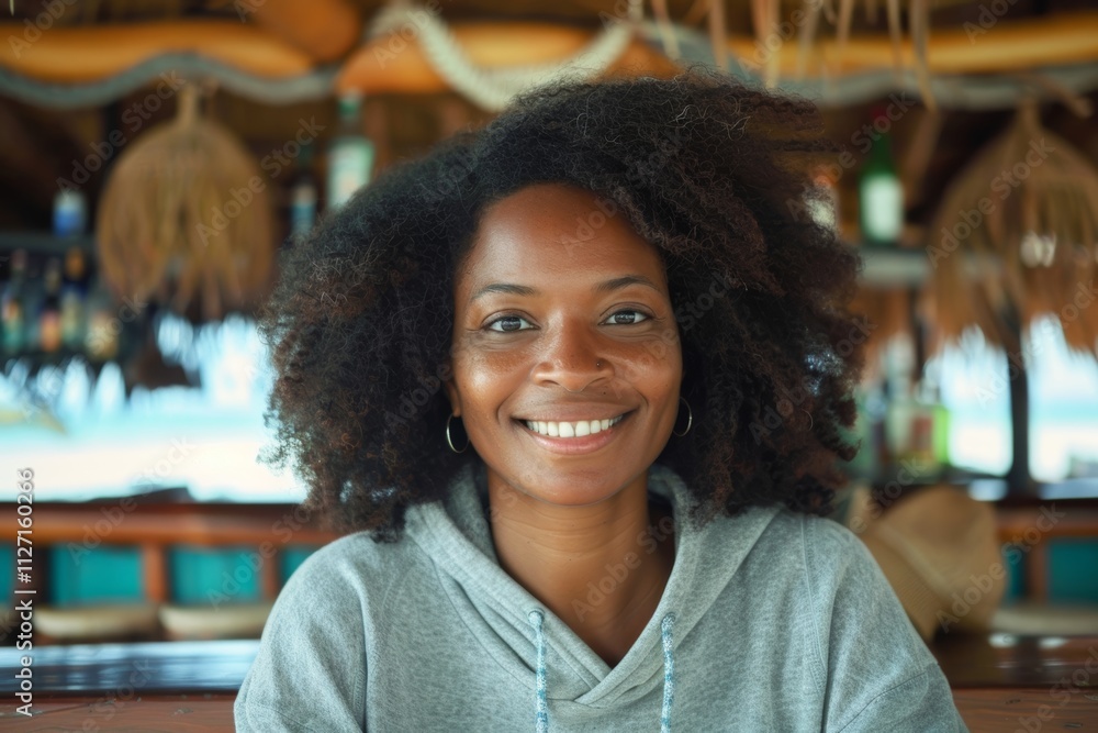 Portrait of a happy afro-american woman in her 30s sporting a comfortable hoodie while standing against tropical beach bar background Portrait of a happy afro-american woman in her 30s sporting a comfortable hoodie while standing against tropical beach bar background