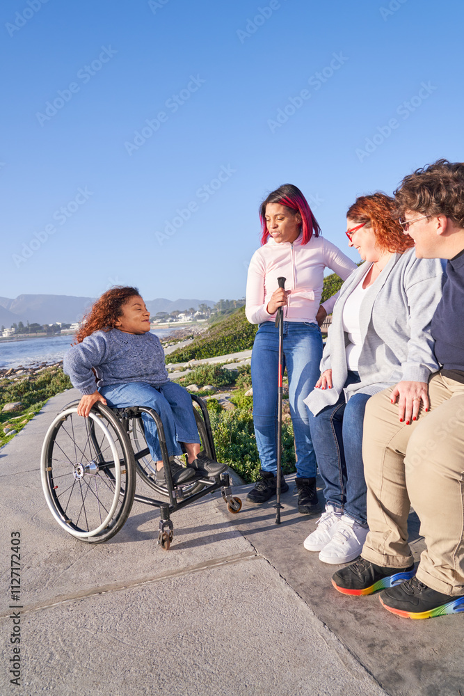 Woman in wheelchair talking to friends outdoors