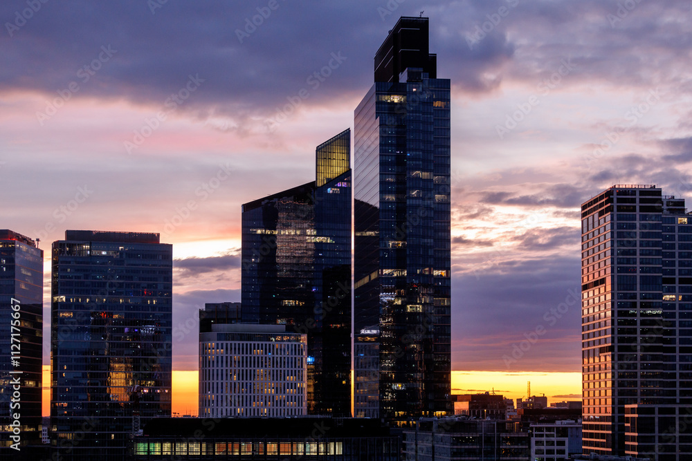 Obraz premium A cityscape with modern architecture under a beautifully colorful dusk sky.