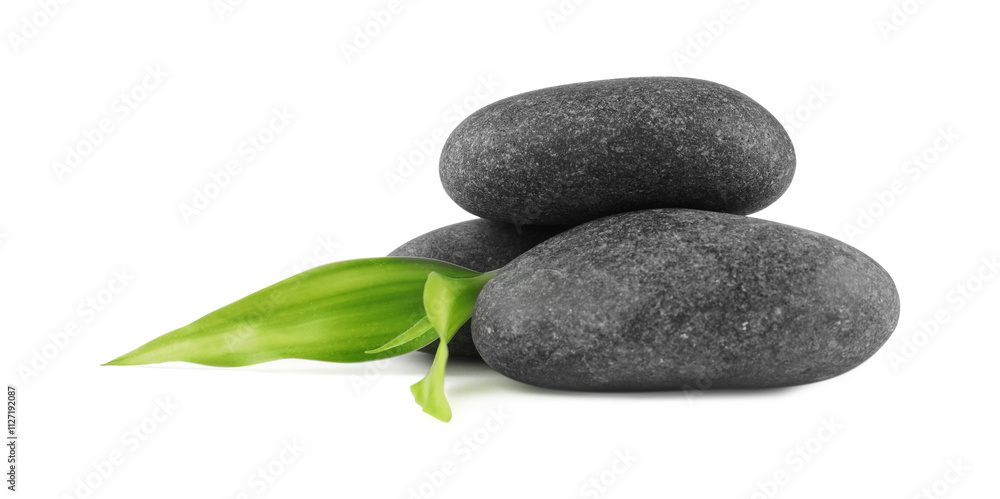 Fototapeta premium Spa stones and green leaves isolated on white