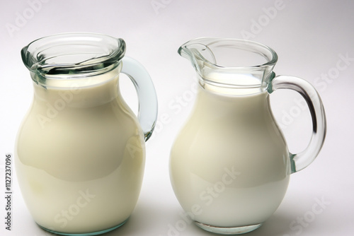 Jug of milk on white background. Jug of milk with gray background. Jug of milk with a transparent background and a glass. A glass jug with a transparent lifestyle background of milk.