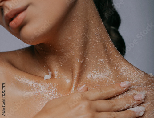 Close-up of a woman exfoliating her skin with a body scrub during a skincare routine