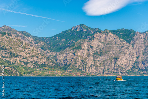 Beautiful peaceful lake Garda, Italy. Lake and yellow boat. photo