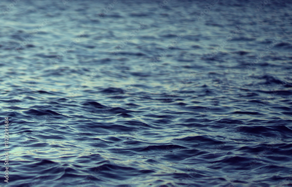 Naklejka premium A water surface with small waves, a beautiful ocean closeup.