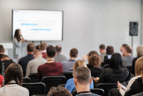Business seminar attendees listening to a speaker. Engaged audience in a conference setting, focusing on professional growth and learning.