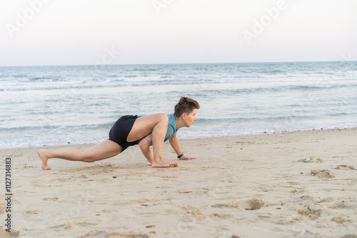 Foto Sporty woman is engaged in animal flow gymnastics outdoors on sea beach