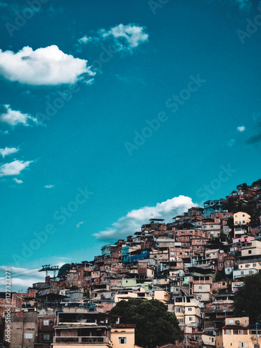 Visão de uma favela em um morro com um céu azul com nuvens photo