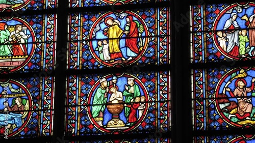 Stunning stained glass windows displaying biblical narratives at Notre Dame Cathedral in Paris, Île-de-France, France