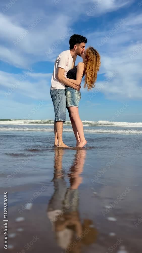 young couple in love kissing on the beach standing in the ocean on summer day young couple in love kissing on the beach standing in the ocean on summer day
