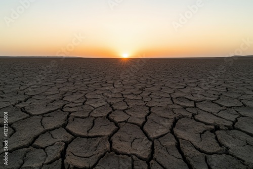 Dried landscape with sunset over cracked earth in the desert
