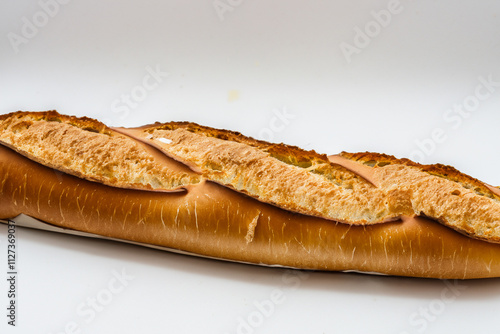 Long french bread on white surface. Baguette with bread and white background. Baguette with a long white light lying on a long background. A baguette with light bread lies on lifestyle a long white. photo