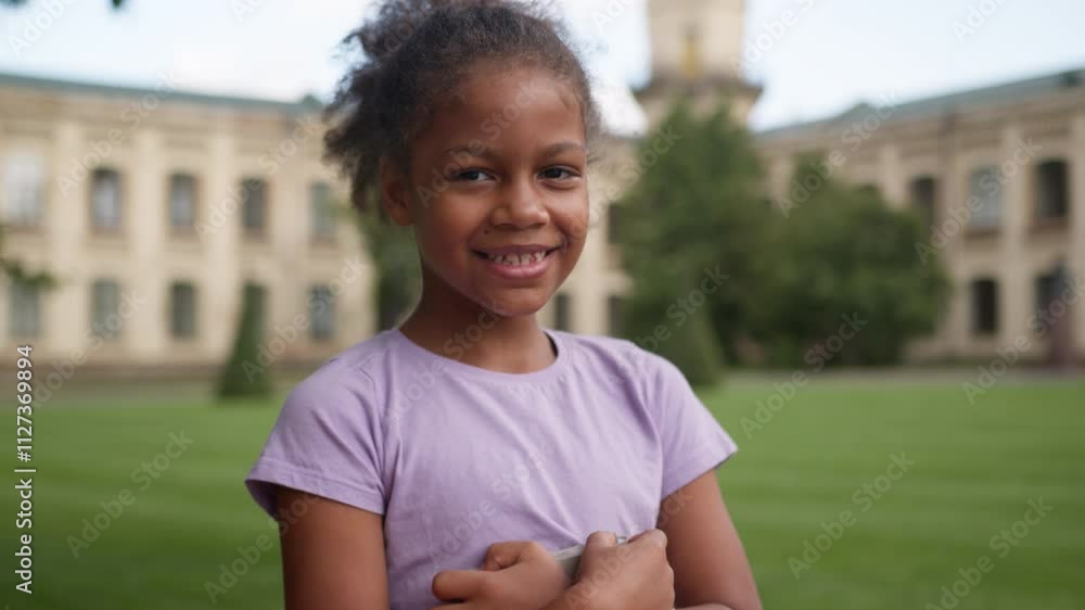 Portrait little African American girl schoolgirl happy ethnic kid child primary elementary school education study learn outdoors city campus smiling pupil student daughter learner looking at camera Portrait little African American girl schoolgirl happy ethnic kid child primary elementary school education study learn outdoors city campus smiling pupil student daughter learner looking at camera