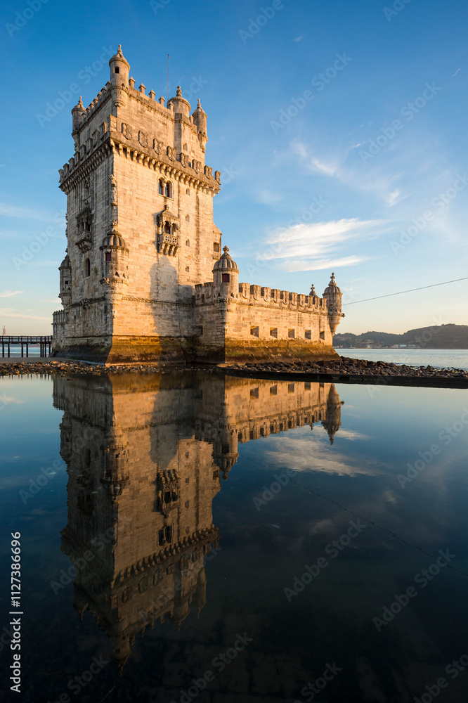 Fototapeta premium Belem Tower (Tower of Saint Vincent) reflecting in the lagoon-like water of the Tagus River surrounding it in Lisbon, Portugal.