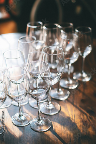 cozy village scene of a Dry January celebration, with empty wine glasses surrounded by pine branches and candles. A celebration without alcohol, with a peaceful, wintery atmosphere.