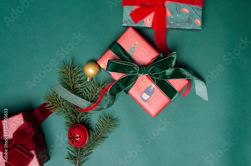 Beautiful Christmas background flat lay with gifts on green with red  ribbons and pine branches